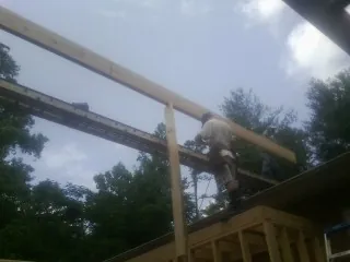 Carpenter setting a ridge beam over a new addition frame — Ice Dam Removal by Roofing Brothers in Chadwick