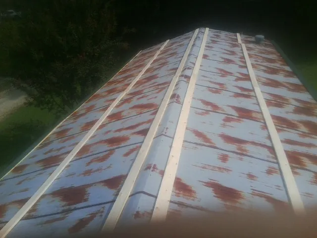 Rusted metal roof panels with new wood purlins before replacement — Storm Damage Roof Repair in Chadwick by Roofing Brothers