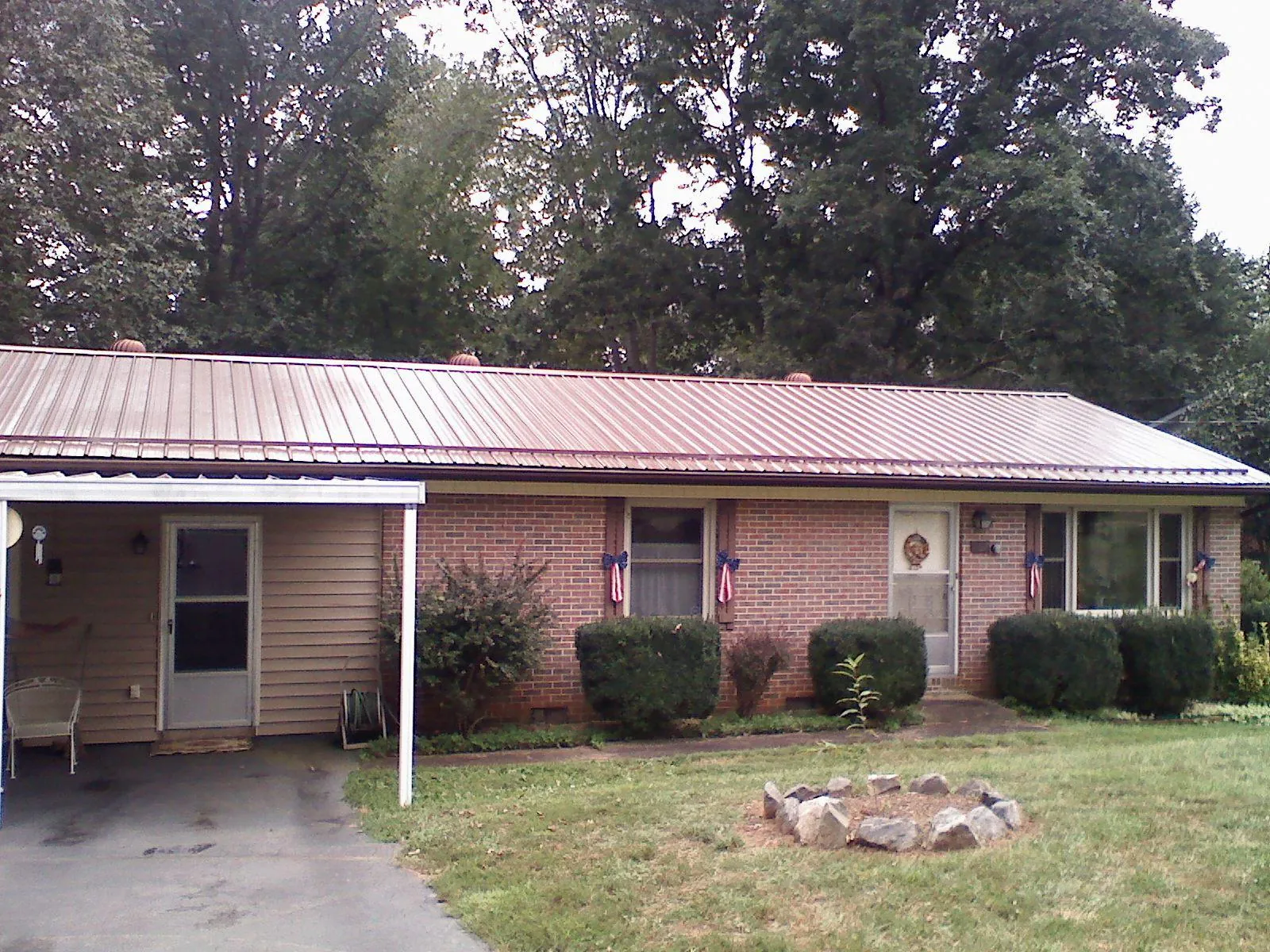 Bronze metal roof and carport on a brick ranch home — Roof Repair work by our crew in Chadwick